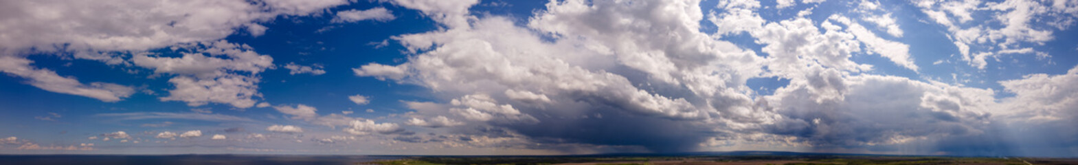 Wall Mural - an extremely wide panorama of a blue colored summer sky with white to gray clouds. along the bottom 