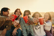 © Jacob Lund - Group of friends cheering and drinking with happiness outdoors