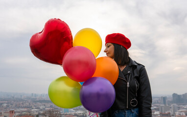 woman holding colorful balloons against the sky