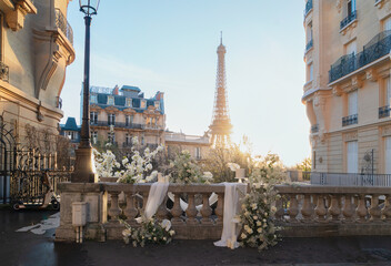 Wall Mural - cosy paris street with view on the famous eiffel tower on spring day with white flowers decorations,