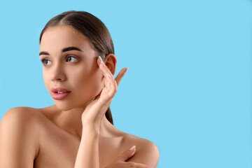 Portrait of attractive young woman on light blue background