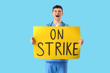 Poster - Protesting male doctor holding placard with text ON STRIKE against blue background