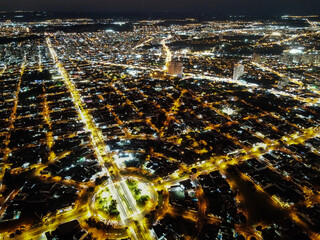 Vista aérea noturna de uma cidade com rotátoria em destaque