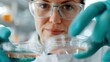 © LifeMedia - A focused scientist wearing safety glasses and gloves carefully handles petri dishes containing samples in a high-tech laboratory for scientific research.