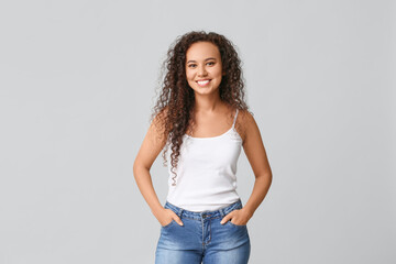 Wall Mural - Happy young African-American woman on white background