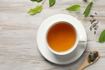 Poster - Refreshing green tea in cup, spoon and leaves on light wooden table, flat lay. Space for text