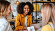 © Roman - Three women smiling and chatting in a cozy office.