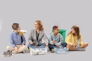 Canvas Print - Pupils with teacher sorting garbage on light background. Ecology concept