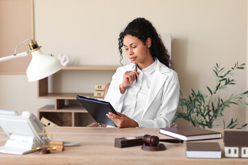 Sticker - Female African-American lawyer with clipboard working at table in office