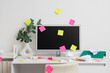 © Pixel-Shot - Messy workplace with computer monitor and sticky notes in light office