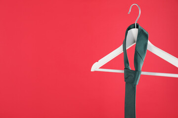 Poster - Hanger with teal tie on red background. Space for text