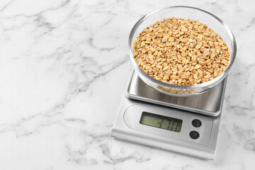 Sticker - Kitchen scale with bowl of dry oats on white marble table. Space for text