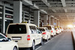 © Kyryl Gorlov - Taxi car Queue yellow taxi symbol  on roof stand waiting at parking of airport terminal or railway station Under Concrete Structure Transportation Hub. Urban street transportation comfort service