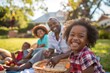 © kitipol - Family enjoying a picnic in the yard, parents watching kids play and everyone laughing and having fun