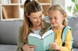 © top images - A woman is reading a book to a little girl
