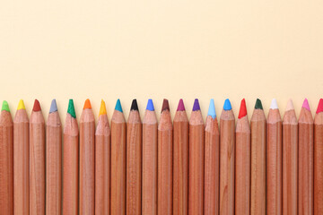 Wall Mural - Equality concept. Different colorful pencils on beige background, top view. Space for text