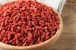 © New Africa - Dried goji berries in bowl on wooden table, closeup