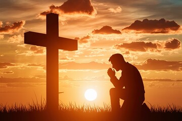 Silhouette of man praying to a cross with heavenly cloudscape sunset concept for religion, worship, love