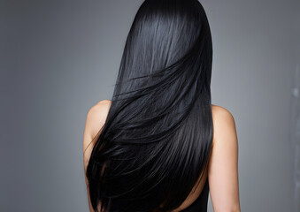 a woman with long black hair is shown with her back to the camera