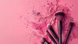 © Sirichat. Camphol - Photo of makeup brush with powder splashes isolated on pink background.