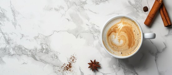 Poster - Top view of a cup with coffee and cinnamon sticks on a marble surface providing copy space image.