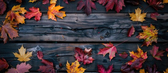 Poster - An autumn-themed scene featuring colorful leaves scattered across a vintage wooden table with ample copy space image.