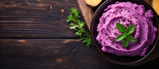 Wall Mural - Top view of a dish with purple sweet potatoes and mashed potatoes on a wooden table, ideal for text placement in a vegan and healthy fruit concept with copy space image.