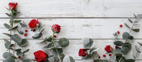 Aufkleber - Top-down image of red rose and flocked eucalyptus branches on a white wooden surface, creating a festive composition ideal for Christmas and New Year, with a winter theme, offering copy space.
