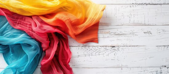 Aufkleber - A colorful fabric napkin lies on a white wooden surface, creating a lovely backdrop for any 'copy space image'.