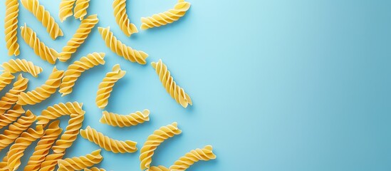 Aufkleber - Trofie pasta uncooked on a light blue backdrop top down view with copy space image