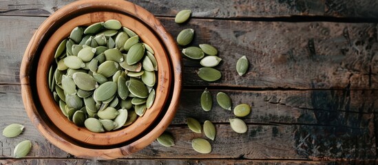 Poster - A bowl of unprocessed pumpkin seeds placed on a wooden table with room for text alongside the image. with copy space image. Place for adding text or design
