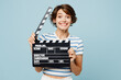 © ViDi Studio - Young cheerful fun woman wear striped t-shirt casual clothes hold in hand classic black film making clapperboard isolated on plain pastel light blue cyan background studio portrait. Lifestyle concept
