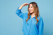 © ViDi Studio - Side profile view young smiling fun woman wear shirt casual clothes hold hand at forehead look far away distance isolated on plain pastel light blue cyan background studio portrait Lifestyle concept