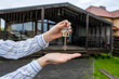 © Antonio - Hand holding keys to new house. Moving relocation concept, real estate concept. Buying or renting