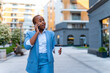 © DusanJelicic - A young businesswoman walks to the office after a break with a coffee in her hand and talks on the phone