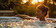 © Kritchanok - a woman relaxing in an outdoor hot tub