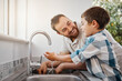 © Lumeez23/peopleimages.com - Faucet, kitchen or washing hands with father and son in home together for bonding, child development or hygiene. Bacteria, sink and water with single parent man teaching boy child how to clean