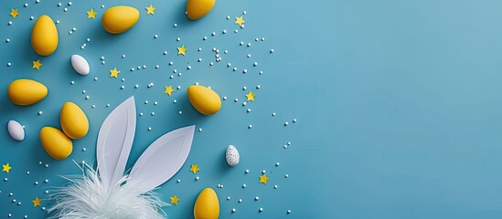 Sticker - Top view of yellow paper eggs fluffy white rabbit ears on a blue background embodying an Easter and spring theme allowing for copy space image