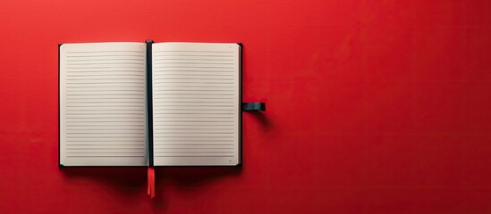 Poster - Top view of an open notebook on a red background laid flat with ample copy space image