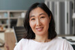 © Maria Vitkovska - Portrait of smiling, attractive Asian woman smiling posing in office looking at camera
