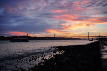 Wall Mural - Sunset on Tagus river in Lisbon. View on the Bridge