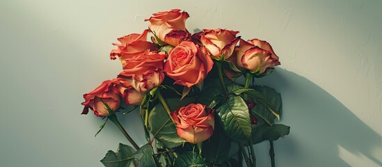 Poster - Flat lay scene captured from above featuring a rose bouquet with leaves on a light table providing ample copy space in the image