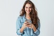 © Kateryna - Happy young woman in denim shirt smiling while using smartphone. Positive emotions and digital lifestyle. Generated AI
