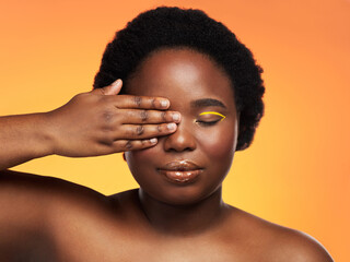 Wall Mural - African woman, makeup and hand on eye for beauty on studio background with cosmetics, afro and lip gloss. Black girl, face and gold eyeliner with glow, shine and facial on backdrop for empowerment