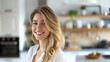 © Ruslan - Young smiling blonde woman in white shirt in modern spacious kitchen