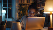 © Sajib - Female typing on laptop under lamp in dim room