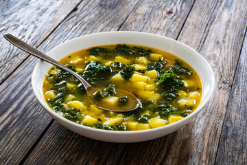 Sticker - Portuguese green soup - Caldo Verde.  Potato and kale soup served in white bowl on wooden table