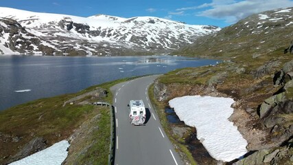 Wall Mural - Aerial view of a camper van on a mountain road near a snowcovered lake, representing adventure and peace, Langvatnet, Geiranger, Norway