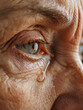 © Concept Island - Older woman crying. Close-up of an elderly woman's eye with a tear sliding down her cheek. Mature people, loneliness and emotions.