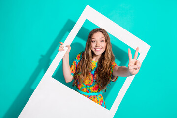 Sticker - Photo portrait of pretty teen girl instant photo frame v-sign wear trendy colorful outfit isolated on aquamarine color background